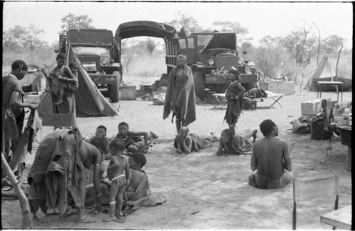 Group of Ju/'hoansi gathering before the two GMC trucks