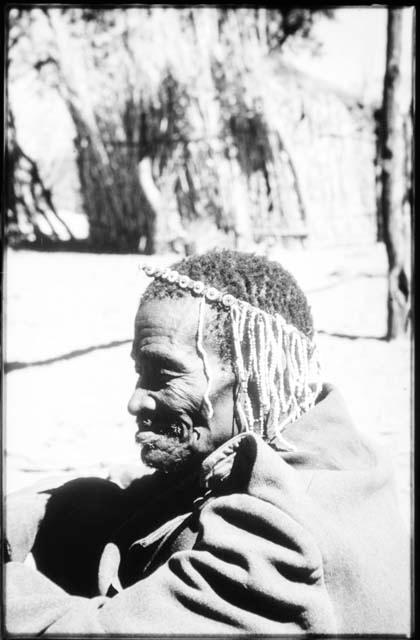 Medicine man holding a rattle and sitting with a group of people (copy of slide 2001.29.7063)