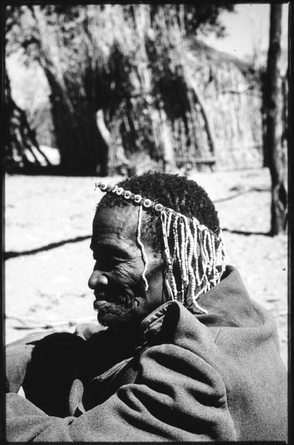 Medicine man holding a rattle and sitting with a group of people (copy of slide 2001.29.7063)