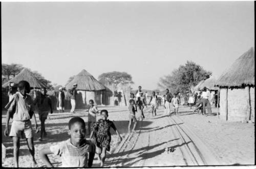 Group of people standing in the road to watch expedition trucks