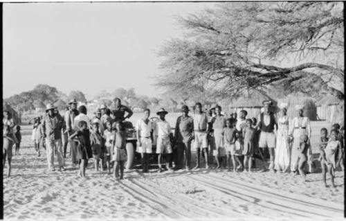 Group of people, including a police officer, standing in the road at Tsau