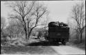 Man standing next to an expedition truck stopped in the track