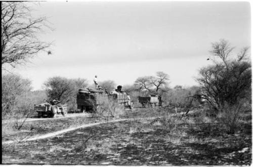 Expedition trucks waiting in burned-over land