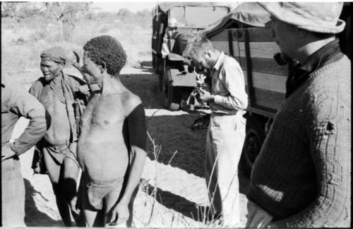 "Old Gau" and Gao, father of N!aba, with Daniel Blitz taking a photograph and Casper Kruger standing next to him