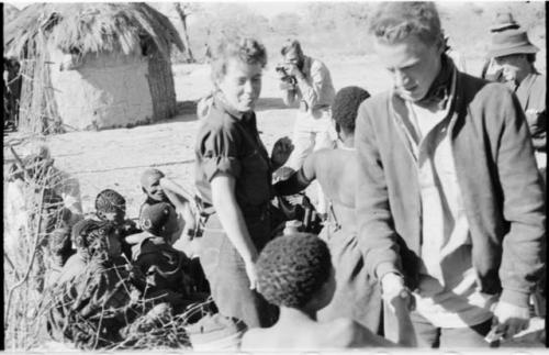 Group of people sitting and one person standing with Elizabeth Marshall Thomas and John Marshall, with Daniel Blitz in the background