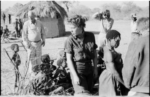 People sitting and standing with Elizabeth Marshall Thomas and Laurence Marshall, with Daniel Blitz photographing in background