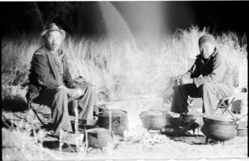 Wilhelm Camm and Philip Hameva sitting at a cooking fire at night