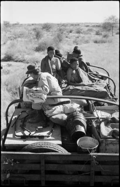 Group of people sitting on top of the expedition truck, including !Ungka, "/Qui Navel" and Lorna Marshall