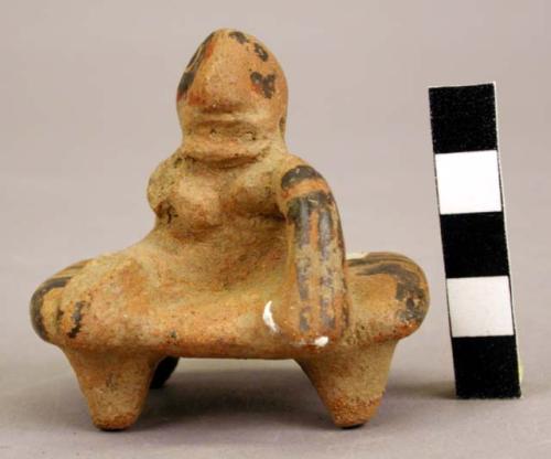 Red and Black Line female effigy seated on 4 legged bench.