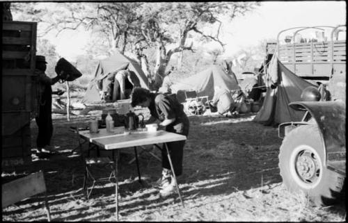 Elizabeth Marshall Thomas leaning over a table in the expedition camp