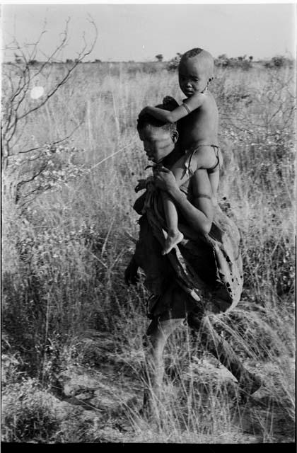 Tsekue carrying N!whakwe on her shoulder