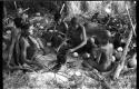 //Kuǂtera, DaSi!Na, and /Twikwe sitting around a fire cooking in a pot