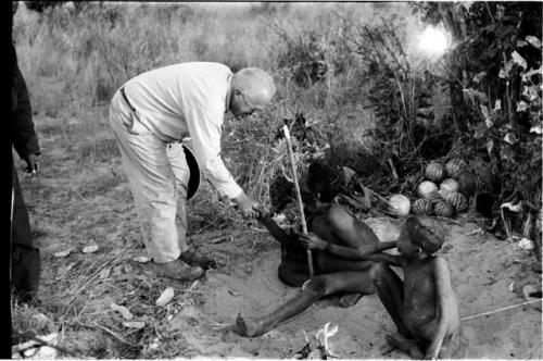 Laurence Marshall shaking hands with Oukwane, /Gaiamakwe sitting