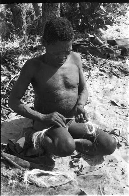 Oukwane making cord, fibers partly rolled