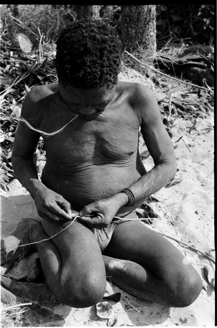 Oukwane rolling cord on his leg, showing the beginning of a splice
