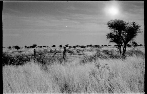 /Twikwe and two children in a patch of cleared ground