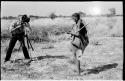 /Twikwe standing with digging stick, being filmed by John Marshall