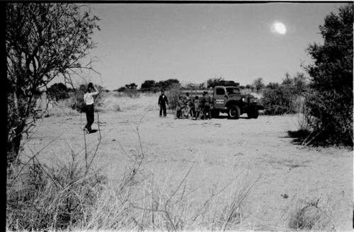 Group of people standing next to a truck, with expedition members walking toward them