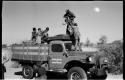 Group of people standing in the back of an expedition truck, with Kernel Ledimo helping them