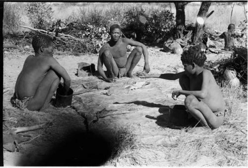 Oukwane, !Gai, and //Kwaiǂkabe sitting in a circle