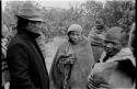 Wilhelm Camm talking with two men, people in the background