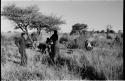 John Marshall squatting, Dabe and another expedition member standing with camera