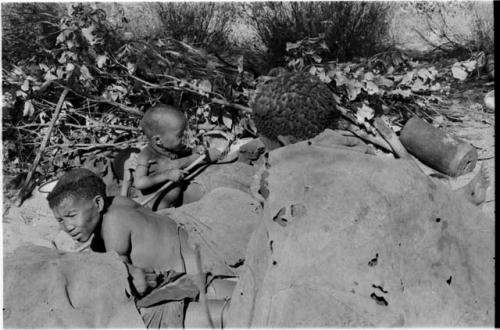 /Twikwe, Dasi!Na and Tsekue lying down; N!whakwe with a stick among them