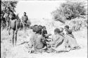 Group of women sitting in the dance circle, with one of the dancing men approaching