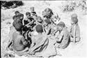 Lorna Marshall speaking with a group of women who are sitting in the dance circle around a fire