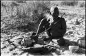 Oukwane playing a musical bow, seated