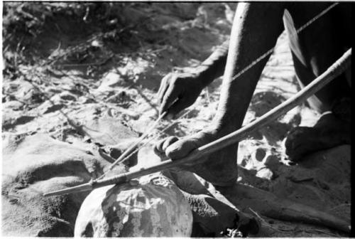 Close-up of Oukwane's hands playing a musical bow