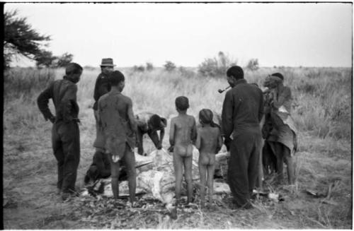 Men skinning a gemsbok, surrounded by a group of people watching