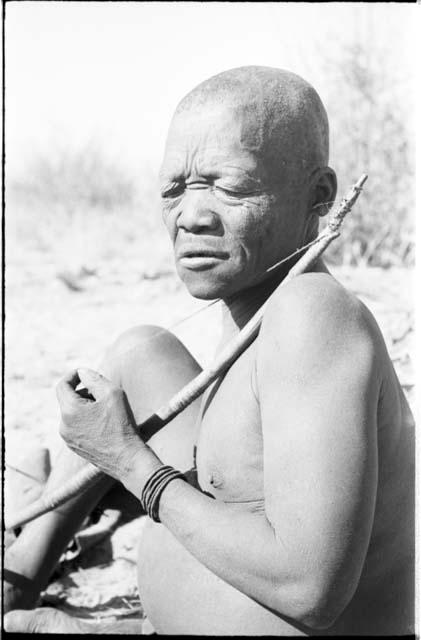 Close-up of Oukwane seated, playing a bow