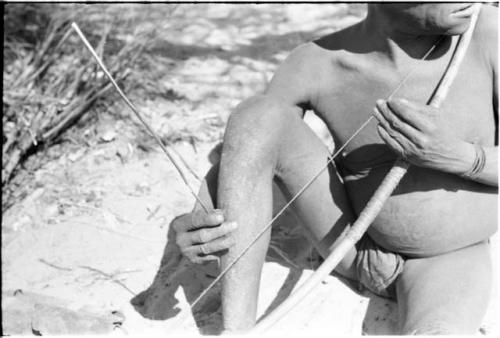 Close-up of Oukwane demonstrating how to play a musical bow