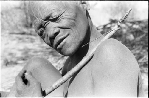 Close-up of Oukwane demonstrating how to play a musical bow