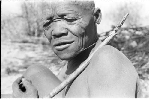 Close-up of Oukwane demonstrating how to play a musical bow