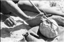 Close-up of Oukwane's hand and foot demonstrating how to play a musical bow