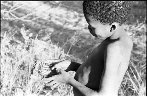 Boy playing a sanza, showing fingering in detail