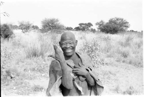 "Kind Man" making an animal gesture with his hand, half figure