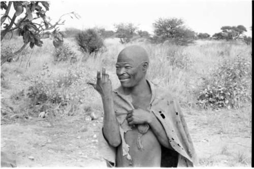 "Kind Man" making an animal gesture with his hand, half figure