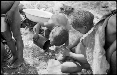 Two children holding tins