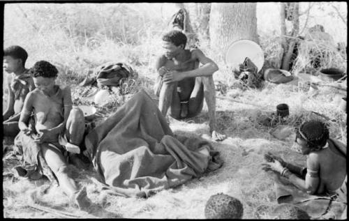 /Naoka, Di!ai and Gao sitting, and a group of children under a kaross