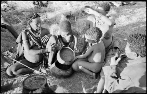 Di!ai, !U and ≠Toma sitting, and Norna and Debe playing with a broken bowl