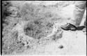 Casper Kruger standing next to a pits and a rock formation near the Herero Reservation, close-up