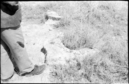 Casper Kruger standing next to a pits and a rock formation near the Herero Reservation, close-up