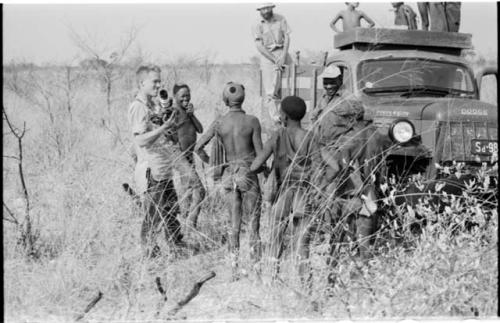 Group of people standing around expedition truck, including Kernel Ledimo and John Marshall