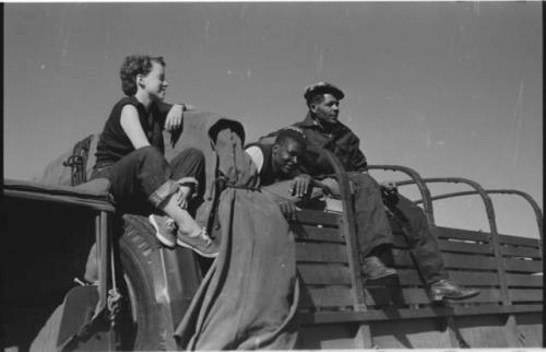 Philip Hameva, Heinrich Neumann and Elizabeth Marshall Thomas sitting on the top of an expedition truck