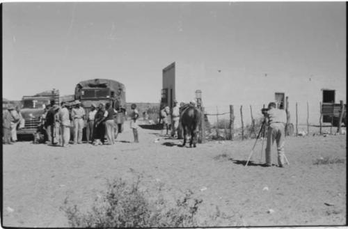 Groups of people and trucks at a trading post