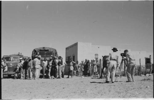 Groups of people and trucks at a trading post