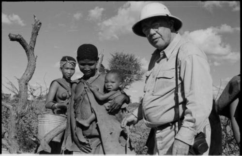 Two women standing with Laurence Marshall, one is holding a baby